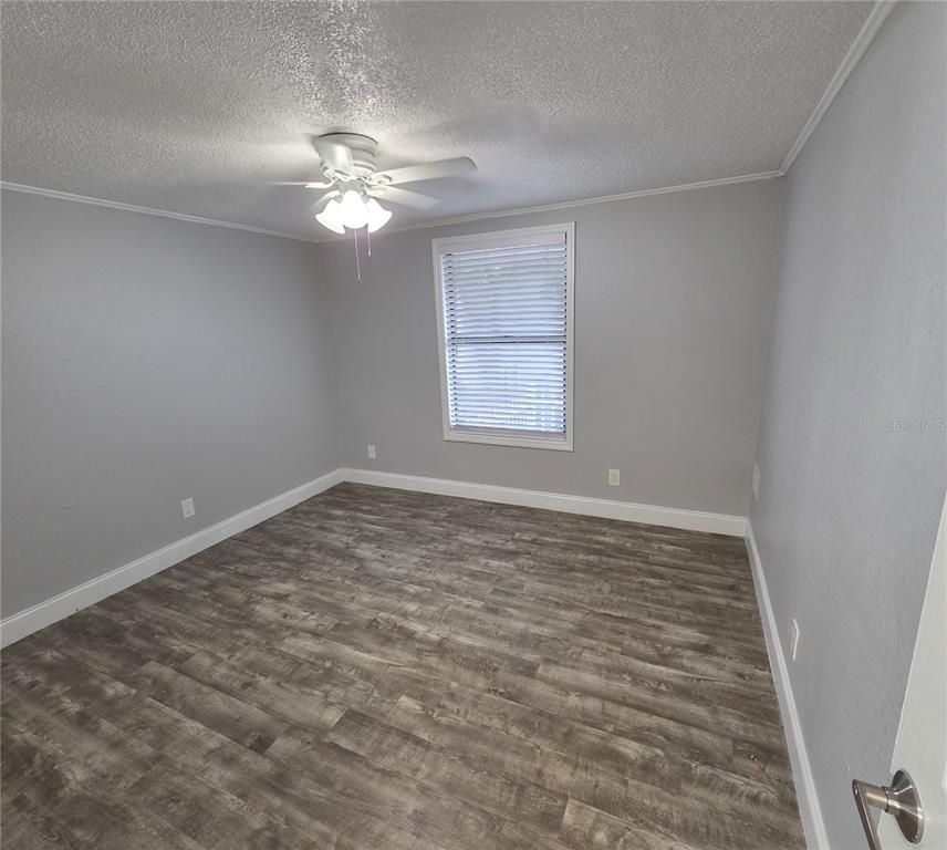 1400 Strawberry Place, Unit 6 Plant City, FL 33563 - Photo 8 of 11 a view of a room with a ceiling fan and hardwood floor