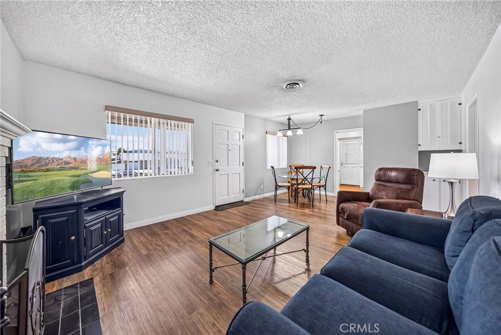 29078 Bradley Road Menifee, CA 92586 - Photo 11 of 42 a living room with furniture a flat screen tv and kitchen view