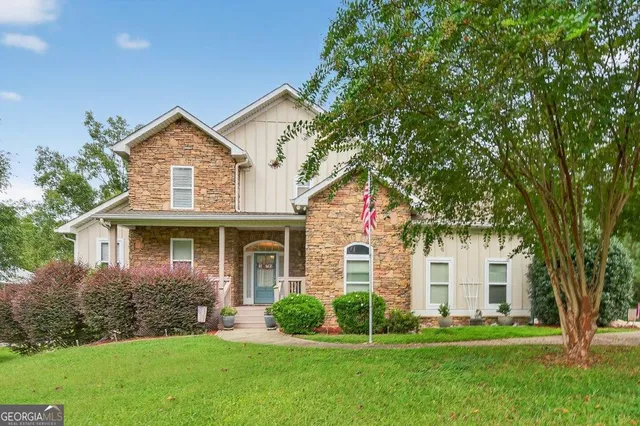 a front view of a house with a yard and green space