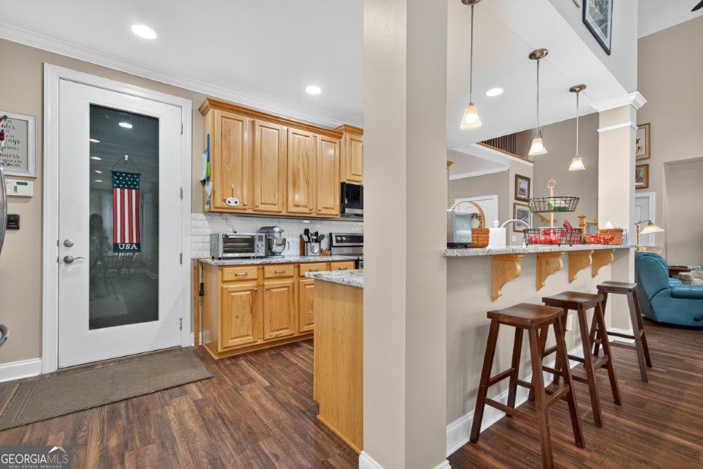 281 Jule Ingram Road Milledgeville, GA 31061 - Photo 12 of 79 a kitchen with stainless steel appliances granite countertop a refrigerator a microwave oven a sink with island and chairs