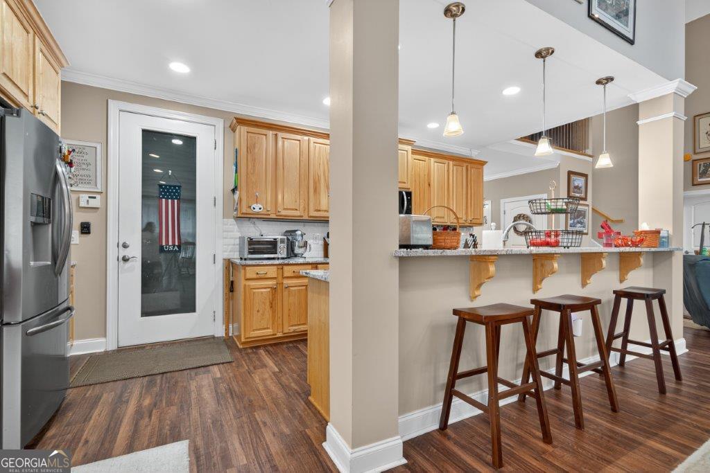 281 Jule Ingram Road Milledgeville, GA 31061 - Photo 13 of 79 a kitchen with stainless steel appliances granite countertop a refrigerator a microwave oven a sink with island and chairs with wooden floor