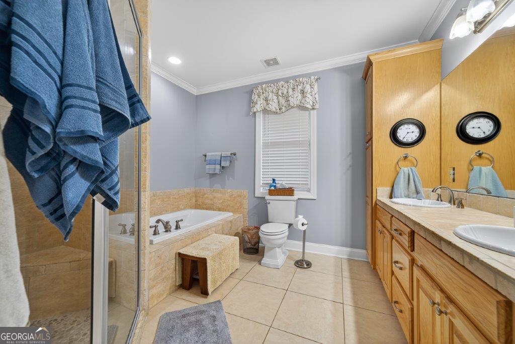 281 Jule Ingram Road Milledgeville, GA 31061 - Photo 23 of 79 a spacious bathroom with a double vanity sink a mirror and a bathtub