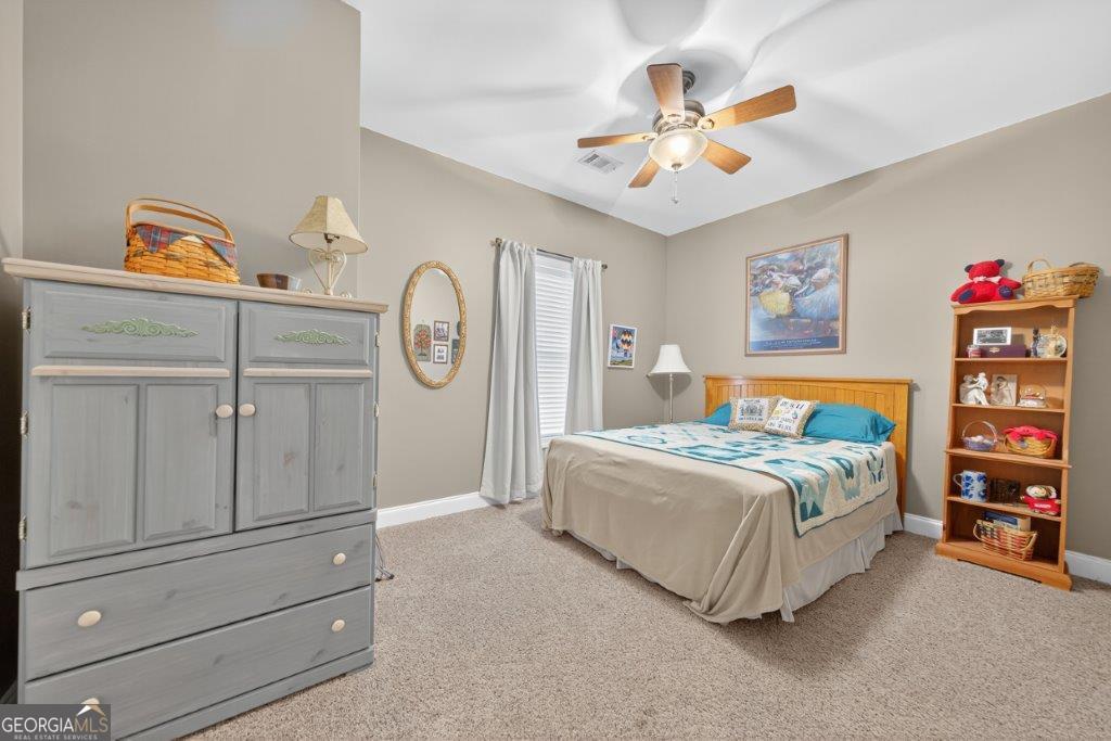 281 Jule Ingram Road Milledgeville, GA 31061 - Photo 33 of 79 a bedroom with a bed and a chandelier