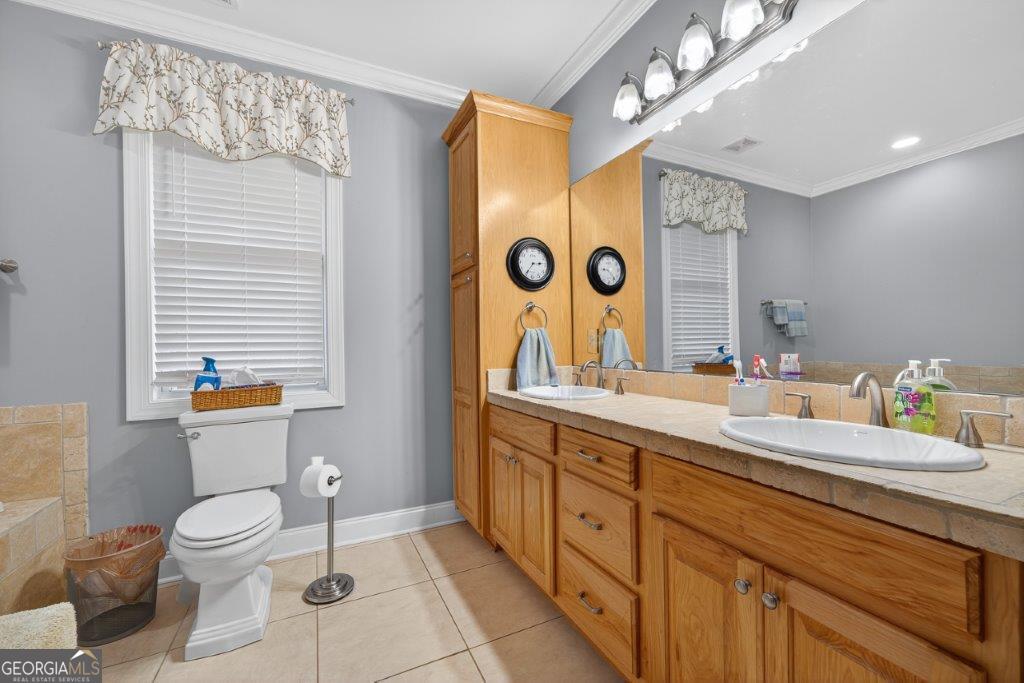 281 Jule Ingram Road Milledgeville, GA 31061 - Photo 37 of 79 a spacious bathroom with a granite countertop sink a toilet a mirror and shower