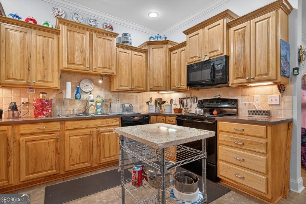 281 Jule Ingram Road Milledgeville, GA 31061 - Photo 44 of 79 a kitchen with stainless steel appliances granite countertop a refrigerator stove microwave and sink with wooden cabinets