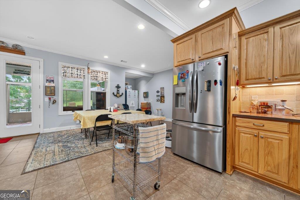 281 Jule Ingram Road Milledgeville, GA 31061 - Photo 45 of 79 a kitchen with a refrigerator a microwave oven dining table chairs and a window