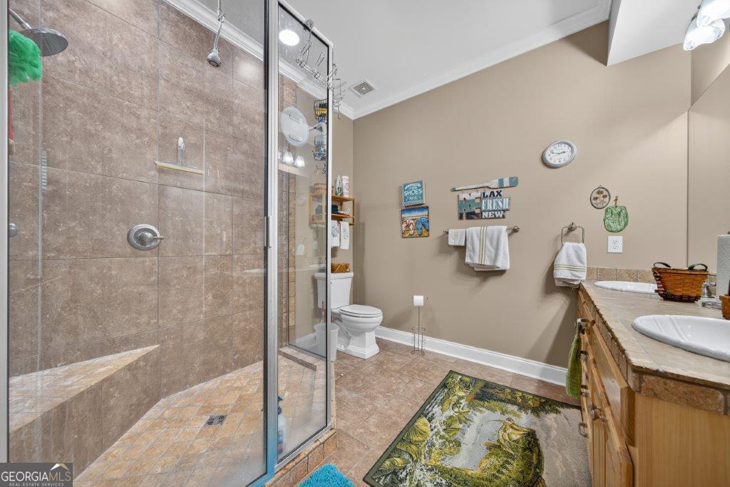 281 Jule Ingram Road Milledgeville, GA 31061 - Photo 52 of 79 a bathroom with a granite countertop sink a toilet and shower