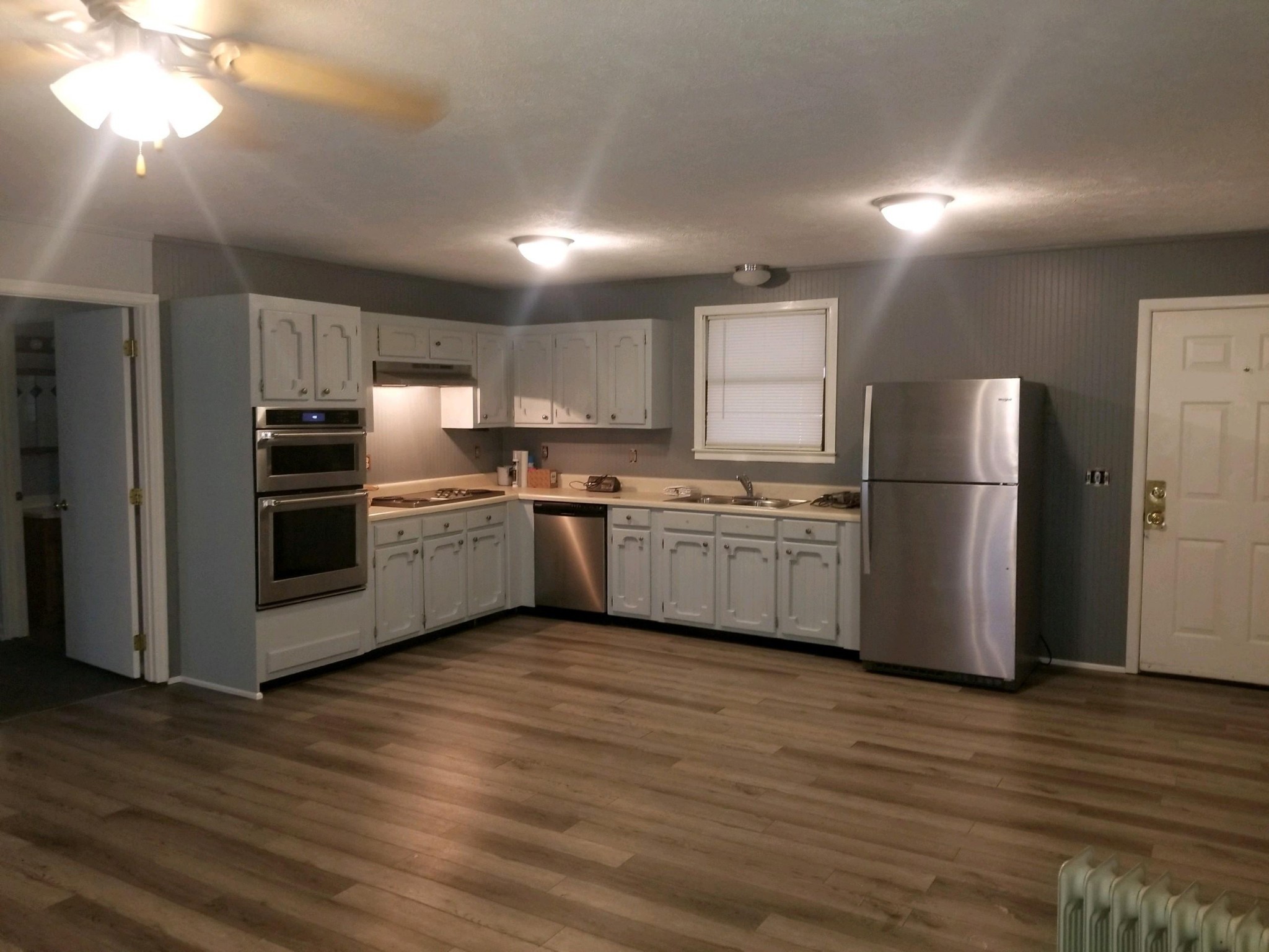 230 Maple Drive Beechgrove, TN 37018 - Photo 2 of 4 a kitchen with kitchen island wooden floors white stainless steel appliances and cabinets