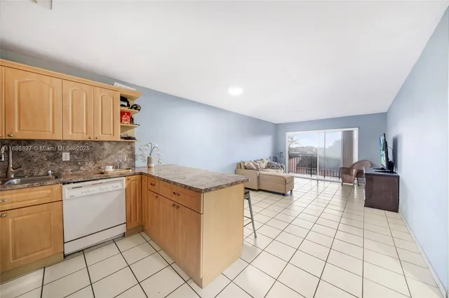 a kitchen with a refrigerator a stove a sink and cabinets