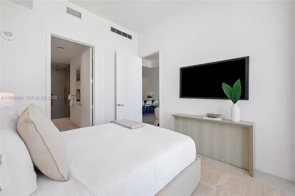 a bedroom with a bed and a flat screen tv