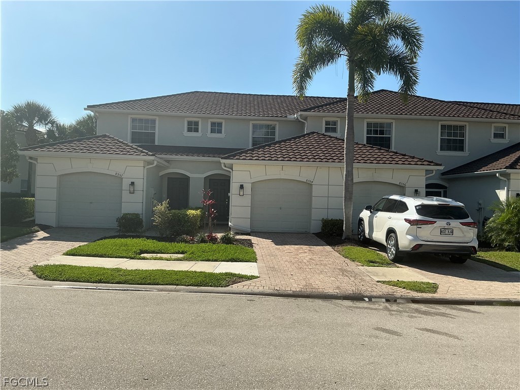 a front view of a house with a garden and yard