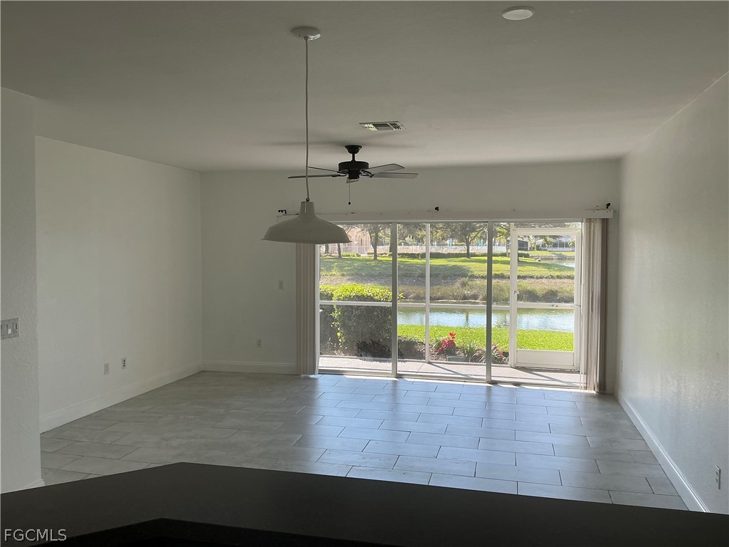 8554 Athena Court Lehigh Acres, FL 33971 - Photo 2 of 22 an empty room with wooden floor and windows
