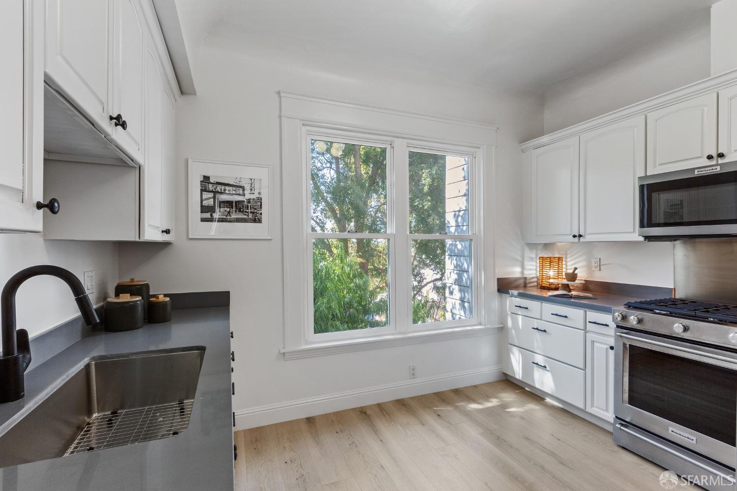 931 Clayton Street San Francisco, CA 94117 - Photo 16 of 28 a kitchen with granite countertop a stove a sink and a microwave