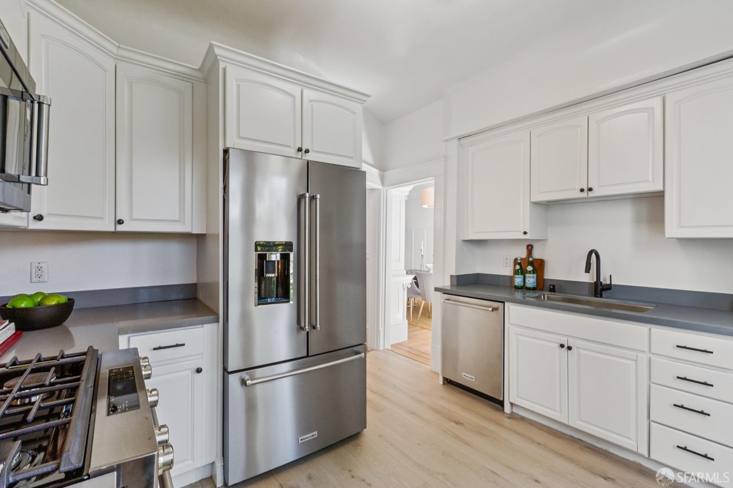 931 Clayton Street San Francisco, CA 94117 - Photo 17 of 28 a kitchen with stainless steel appliances a refrigerator sink and cabinets
