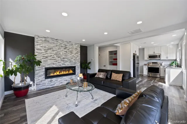 a living room with furniture a fireplace and a potted plant