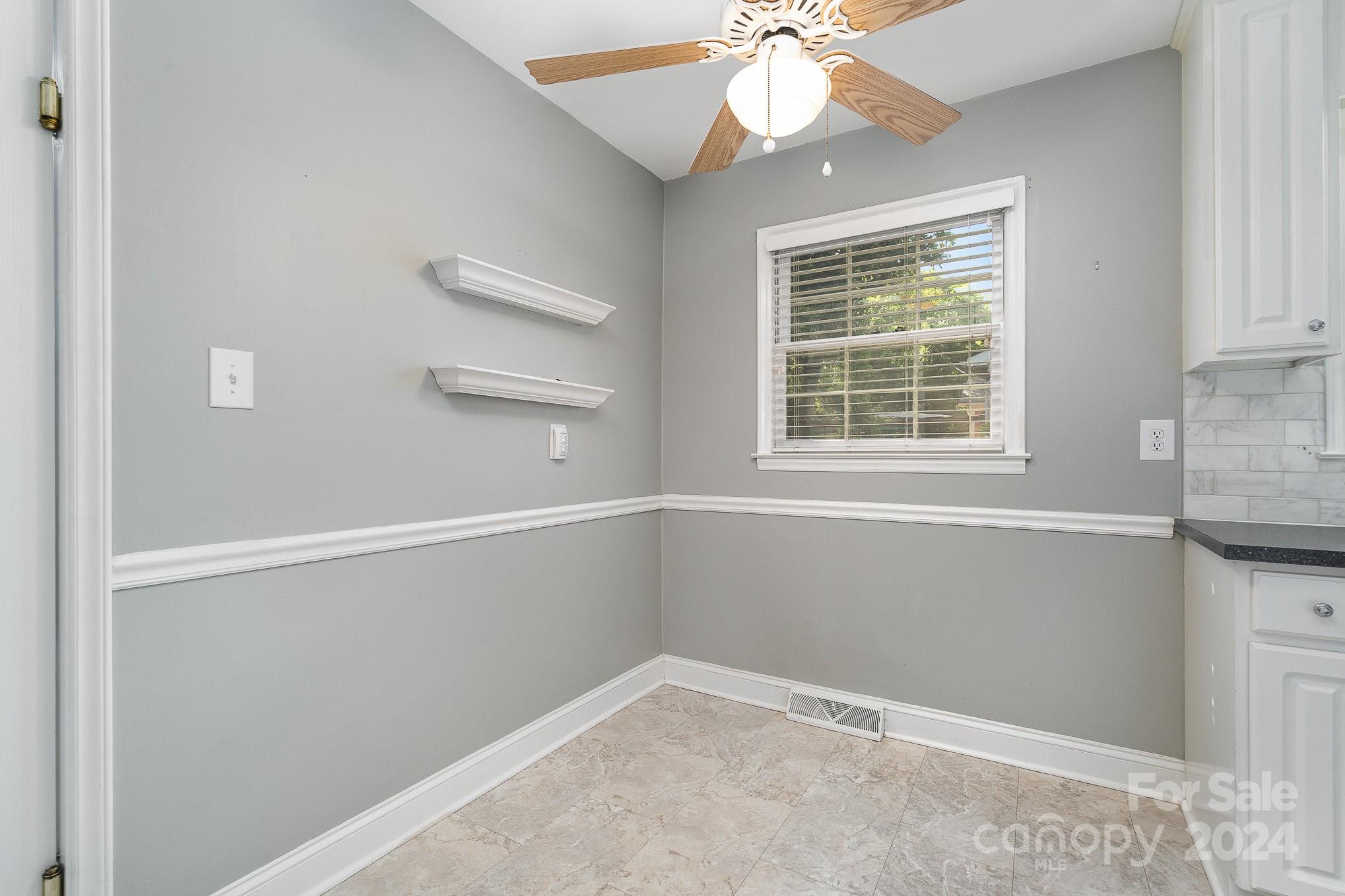 6529 Idlebrook Drive Charlotte, NC 28212 - Photo 14 of 28 an empty room with a window and a chandelier fan