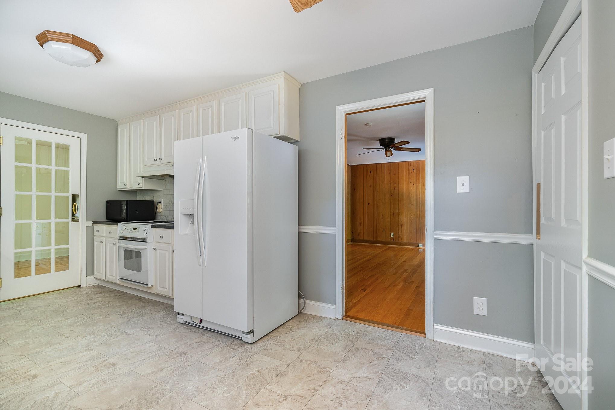 6529 Idlebrook Drive Charlotte, NC 28212 - Photo 15 of 28 a view of kitchen with white cabinets and refrigerator
