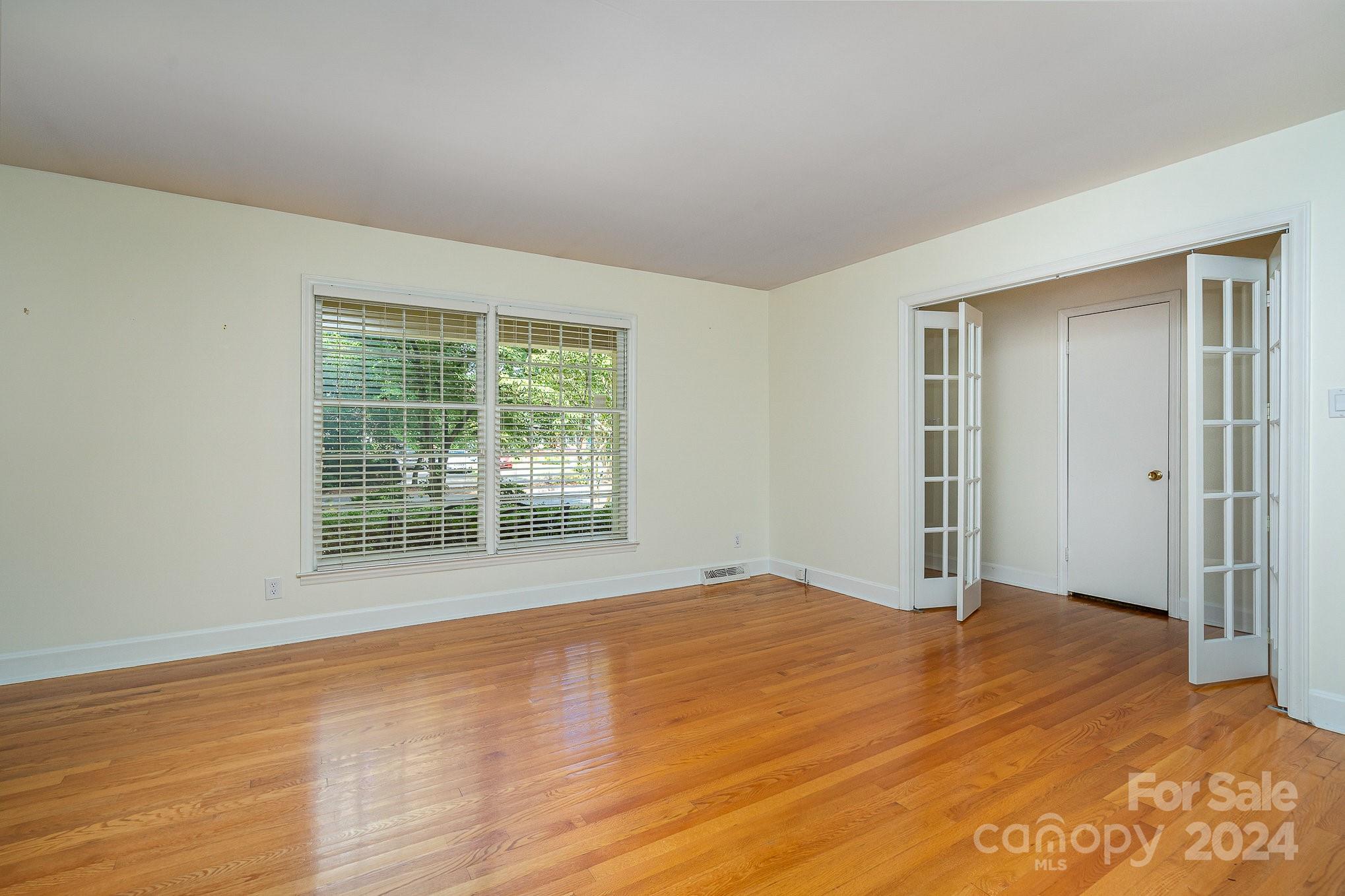 6529 Idlebrook Drive Charlotte, NC 28212 - Photo 6 of 28 a view of an empty room with wooden floor and a window