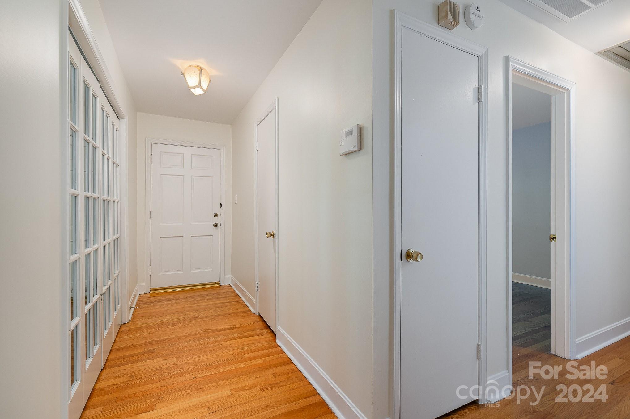 6529 Idlebrook Drive Charlotte, NC 28212 - Photo 10 of 28 a view of a hallway with wooden floor and a bathroom