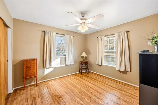 a view of a livingroom with wooden floor and a ceiling fan