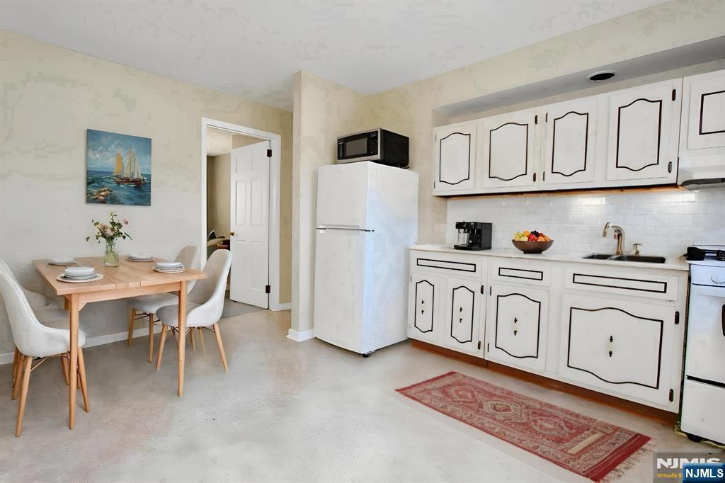 756 Hamilton Street, Unit 3 Harrison, NJ 07029 - Photo 3 of 7 a white kitchen with white cabinets and stainless steel appliances