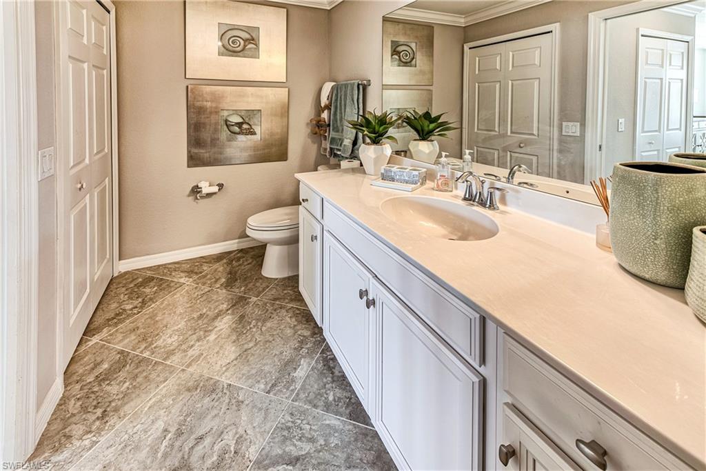 9572 Trevi Court, Unit 5015 Naples, FL 34113 - Photo 13 of 39 a spacious bathroom with a granite countertop sink and a mirror