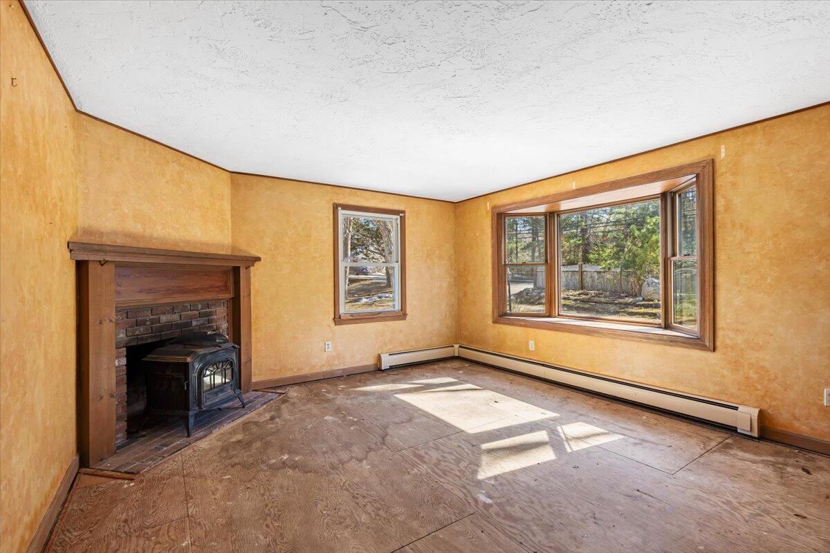 1094 County Road Cataumet, MA 02534 - Photo 7 of 42 a view of an empty room with a fireplace and a window