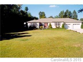 a view of a swimming pool with lawn chairs under an umbrella