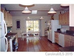 201 Sean Way Hendersonville, NC 28792 - Photo 3 of 8 a kitchen with stainless steel appliances granite countertop a refrigerator a sink dishwasher a dining table and chairs with wooden floor