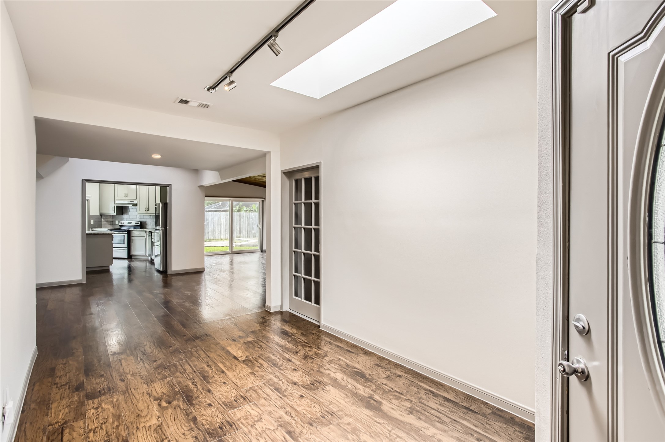 6509 Birdwood Road Houston, TX 77074 - Photo 3 of 26 a view of a hallway with wooden floor and a living room