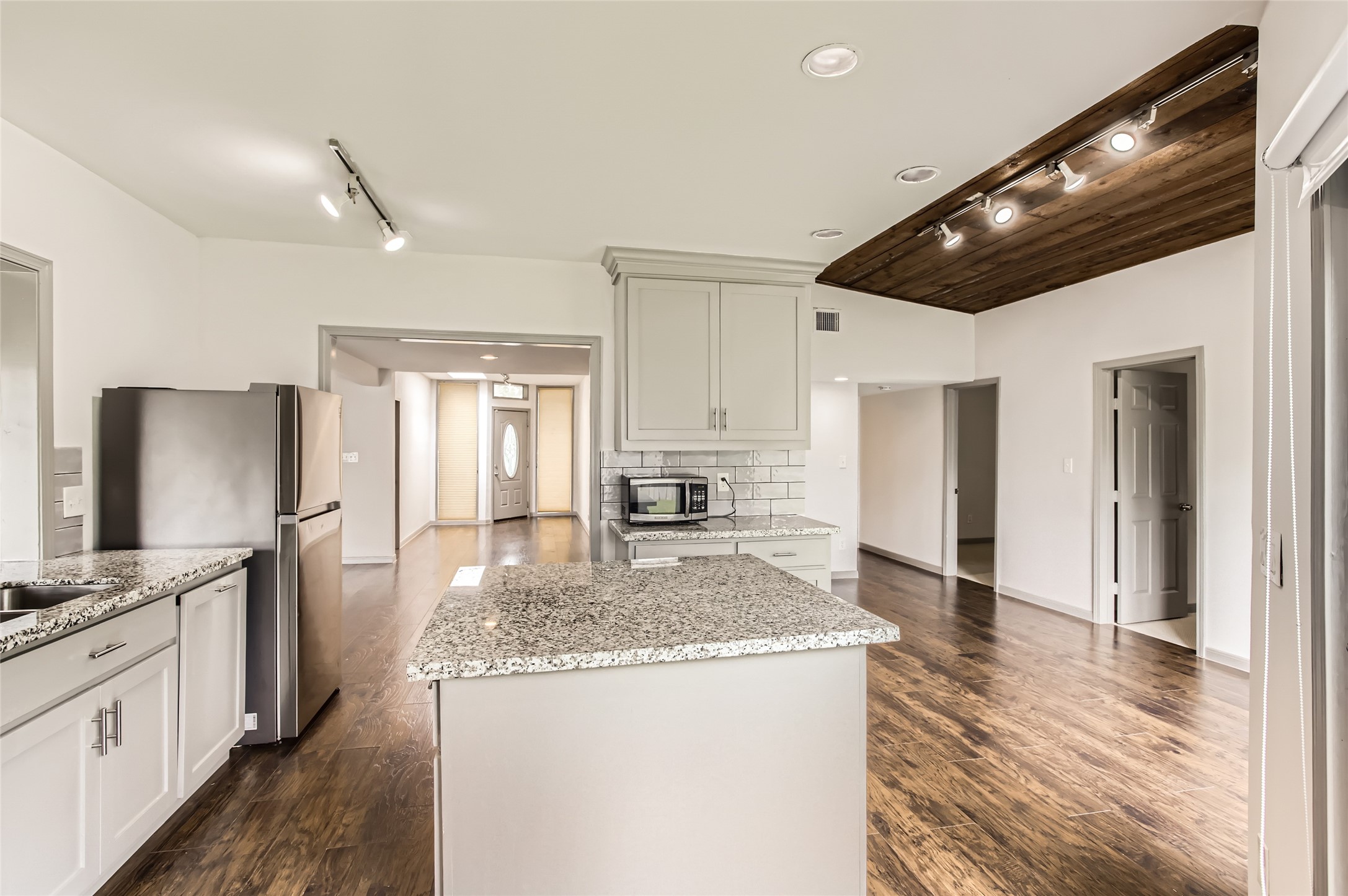 6509 Birdwood Road Houston, TX 77074 - Photo 10 of 26 a kitchen with granite countertop kitchen island a sink stainless steel appliances and cabinets