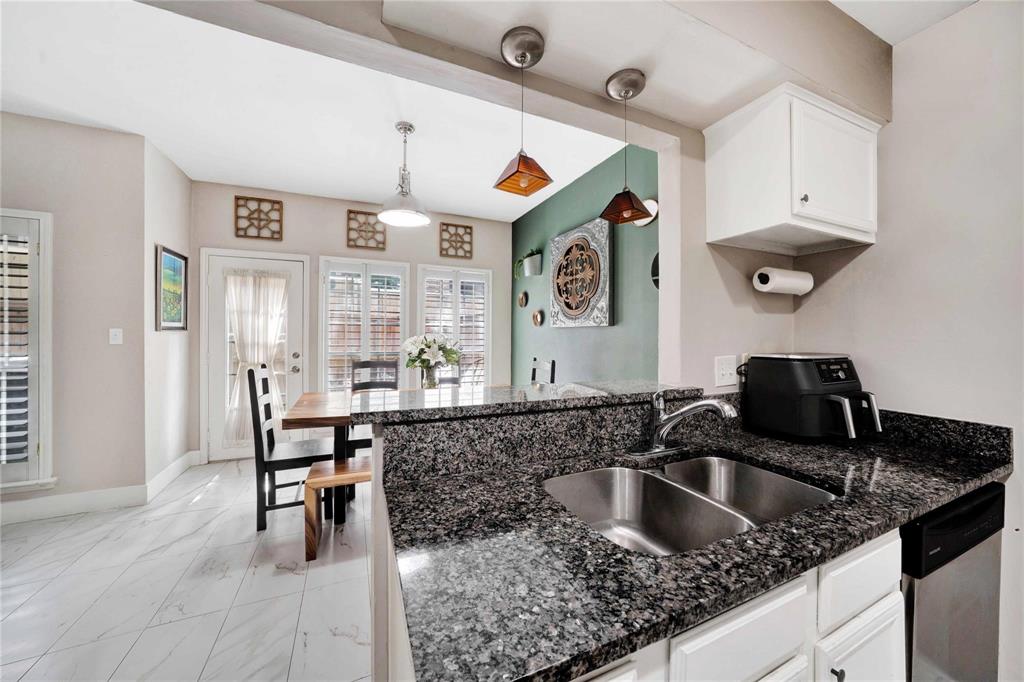 8518 Coppertowne Lane Dallas, TX 75243 - Photo 13 of 32 a kitchen with granite countertop a sink and a refrigerator