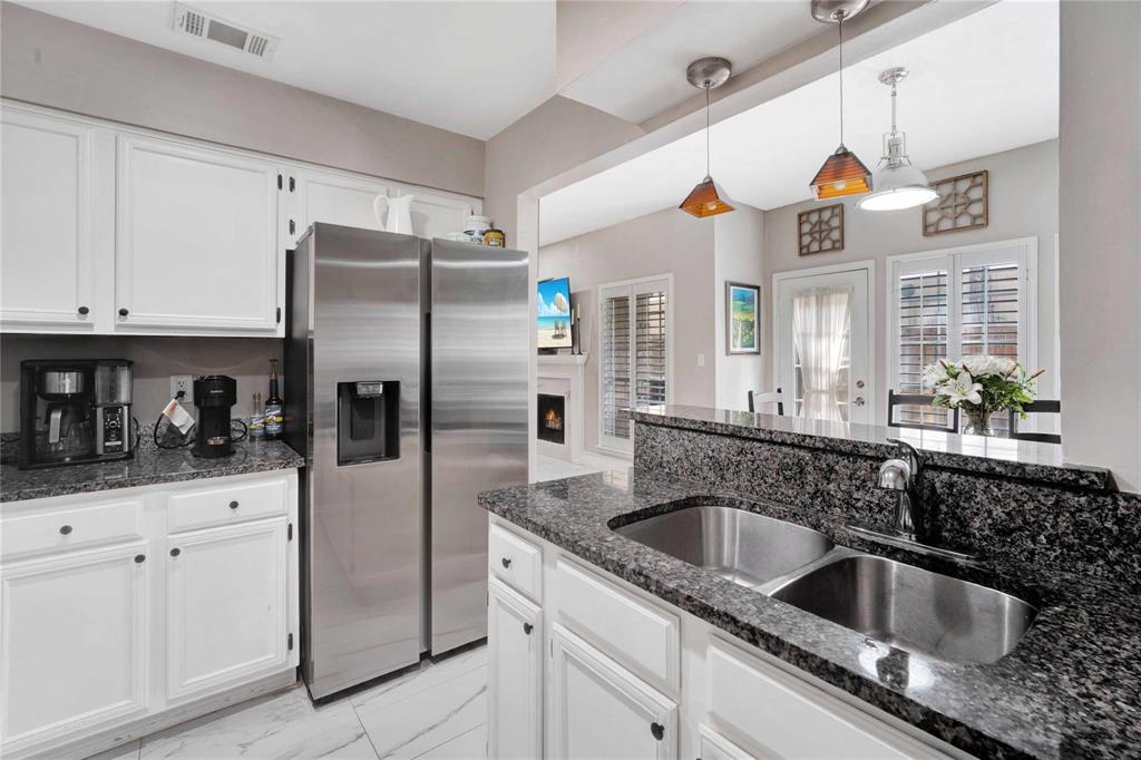 8518 Coppertowne Lane Dallas, TX 75243 - Photo 15 of 32 a kitchen with stainless steel appliances granite countertop a sink and dishwasher a refrigerator with wooden cabinets