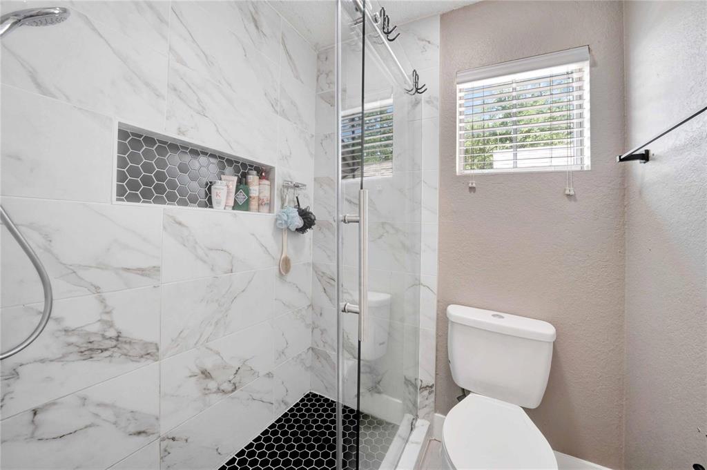 8518 Coppertowne Lane Dallas, TX 75243 - Photo 23 of 32 a bathroom with a toilet and a shower