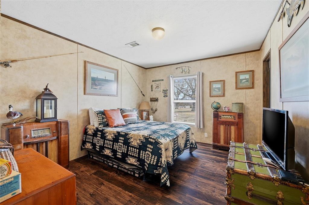 1949 Greer Road Sadler, TX 76264 - Photo 23 of 39 a bedroom with a bed and a flat screen tv