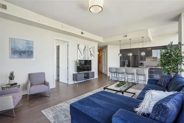 a living room with furniture and view of kitchen