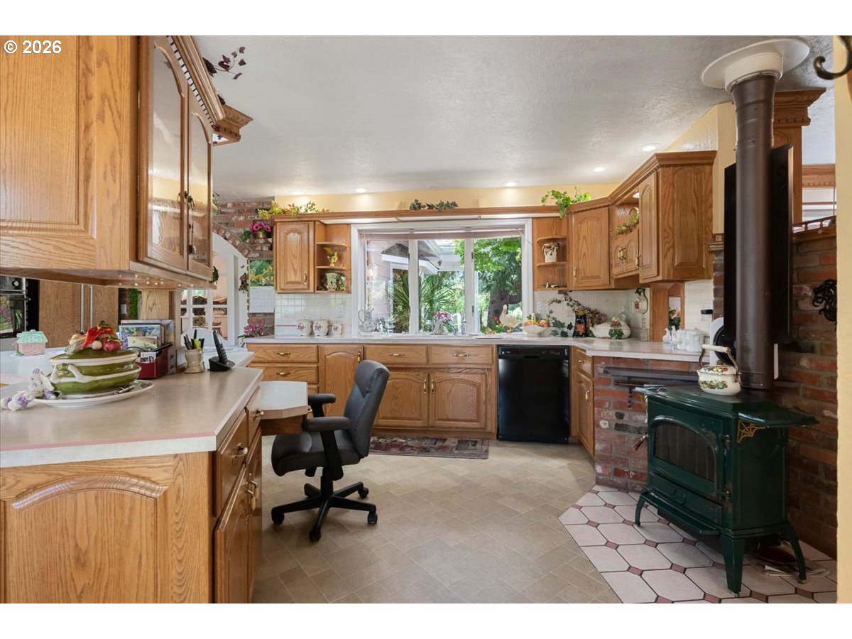 1300 Fair Oaks Road Oakland, OR 97462 - Photo 17 of 48 a kitchen with kitchen island granite countertop a stove a sink a dining table and chairs with wooden floor