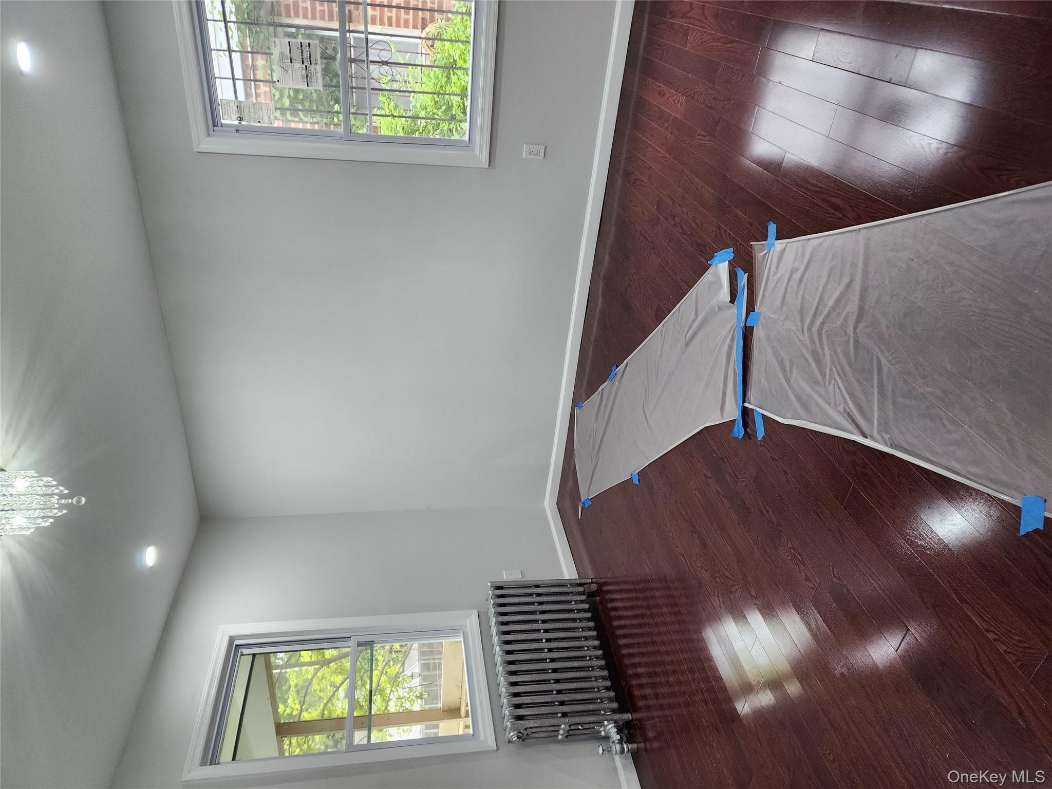 224-06 114th Road Queens, NY 11411 - Photo 5 of 15 Empty room with radiator heating unit, baseboards, hardwood / wood-style flooring, and recessed lighting