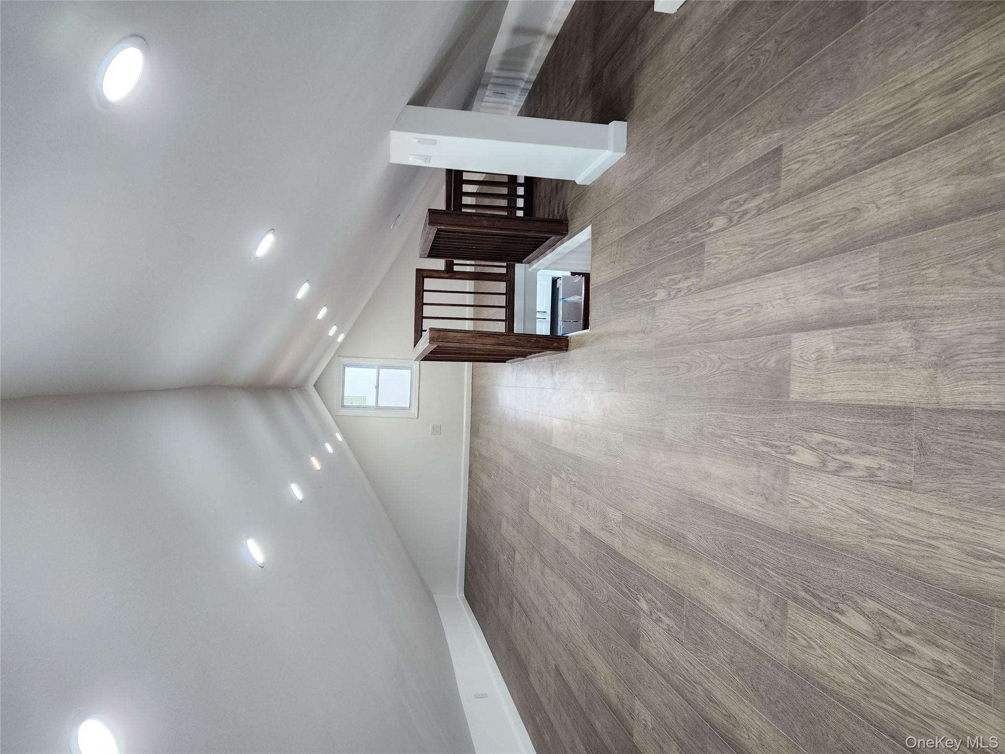 224-06 114th Road Queens, NY 11411 - Photo 8 of 15 Additional living space with wood finished floors, vaulted ceiling, and baseboards
