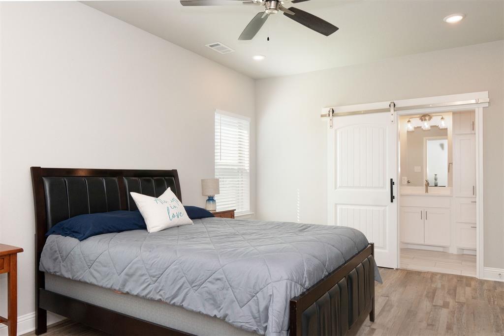 849 County Road 4764 Boyd, TX 76023 - Photo 38 of 40 a bedroom with a large bed and a chandelier