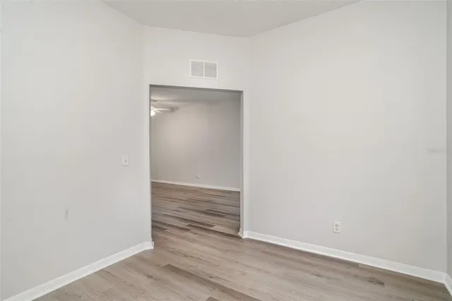 a view of an empty room with wooden floor