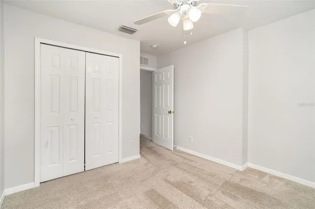 an empty room with a chandelier fan