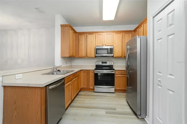 a kitchen with stainless steel appliances a refrigerator and a stove top oven
