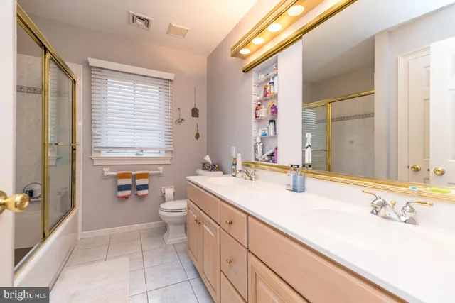 a bathroom with a double vanity sink toilet and shower
