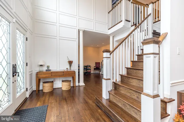 a view of front door with stairs and wooden floor