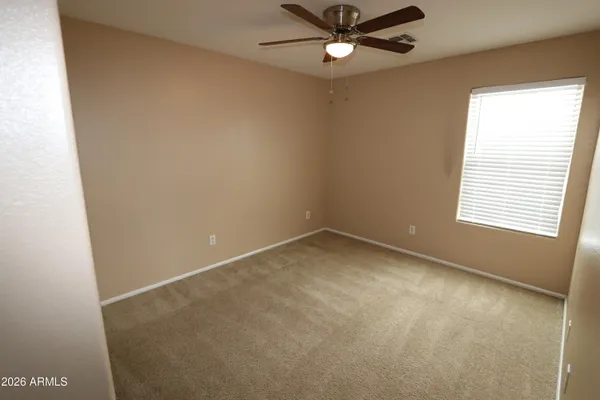 an empty room with a window and a fan