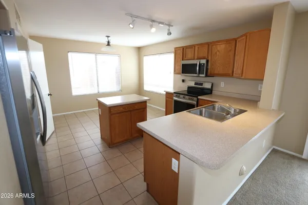 a kitchen with a sink a stove top oven a refrigerator cabinets and a window