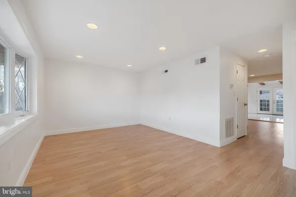 a view of empty room with wooden floor and windows