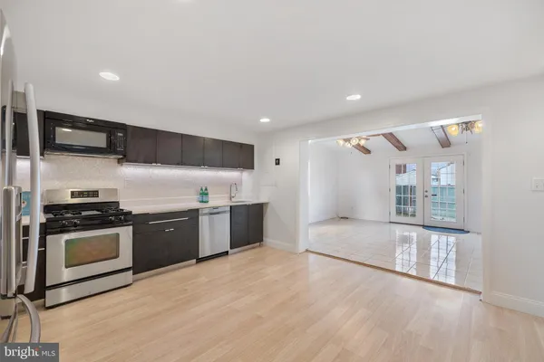 a large kitchen with stainless steel appliances granite countertop a stove and a refrigerator