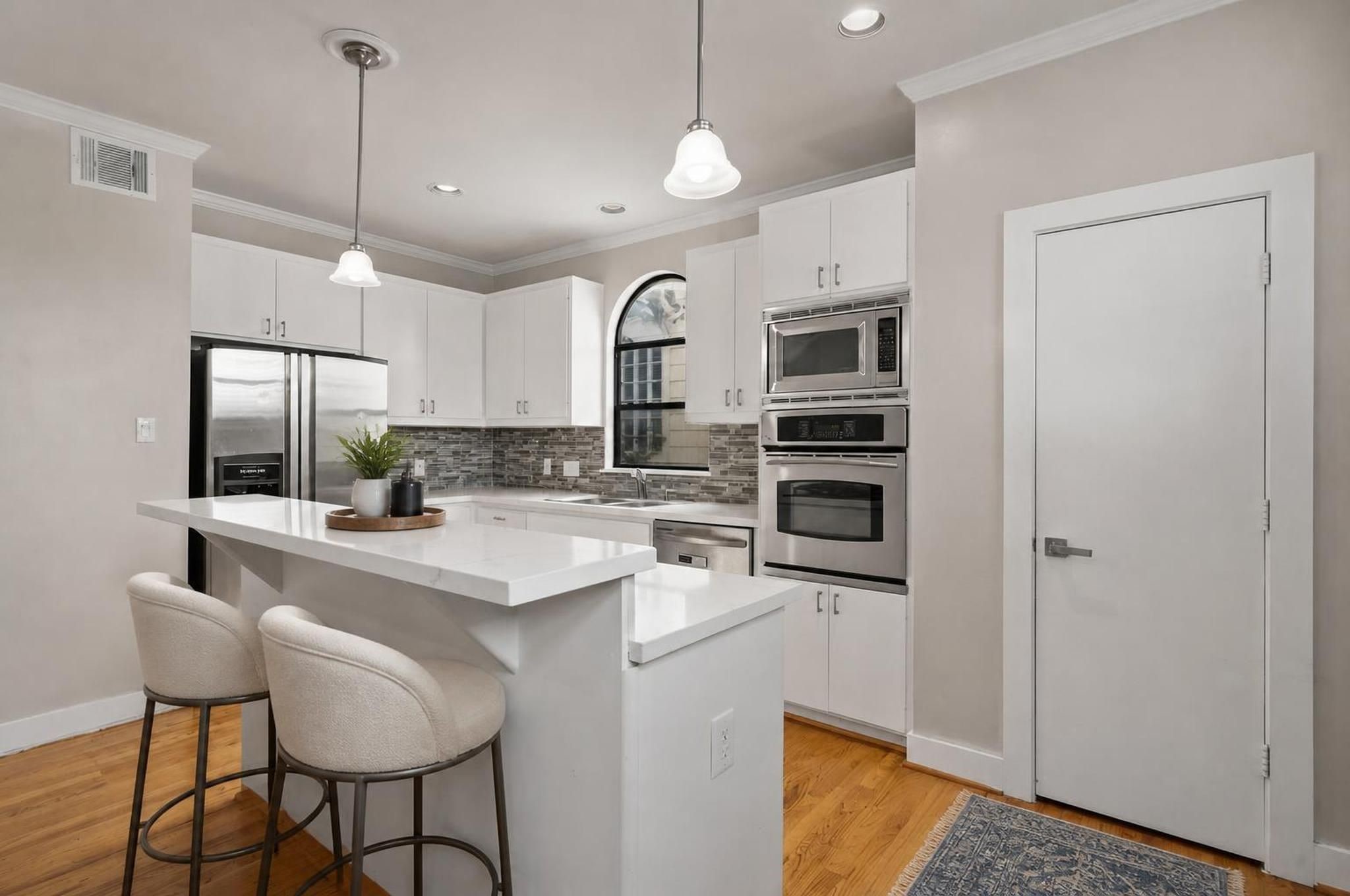 2154 Arabelle Street Houston, TX 77007 - Photo 2 of 45 The kitchen brings a crisp, modern feel to the center of the home with quartz countertops, a breakfast bar, and an island with cooktop. Its open placement keeps the space connected to both dining and living. Virtually staged.